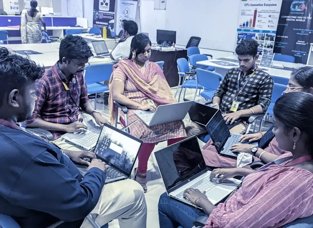 Engineers and trainees working through a problem together on laptops in the KaizenSpark lab