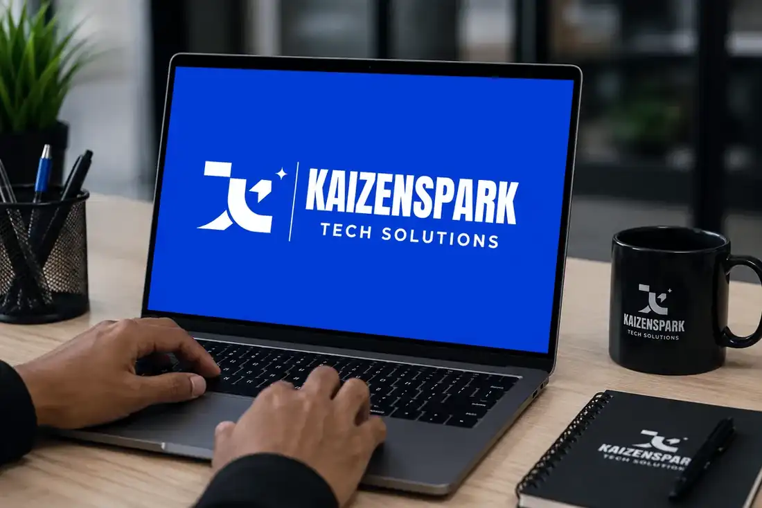 A laptop showing the KaizenSpark Tech Solutions logo beside a branded mug