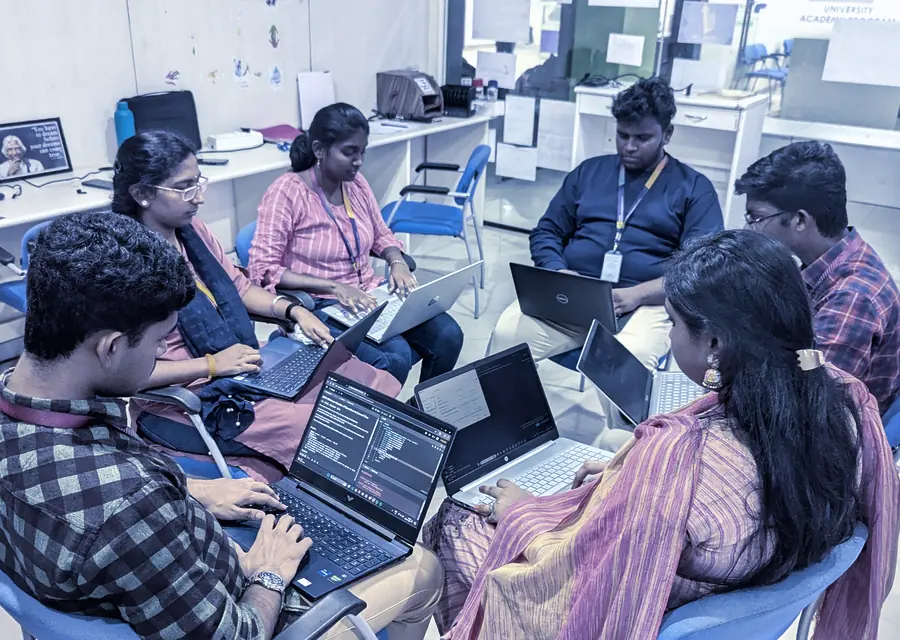 A workshop group seated with laptops, working through a process together