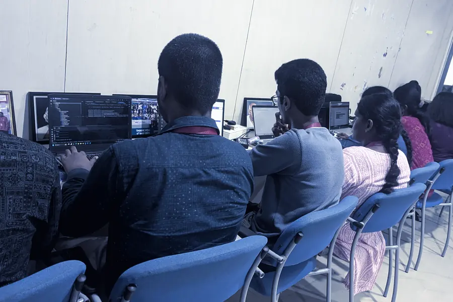 Engineers reviewing work side by side at their monitors